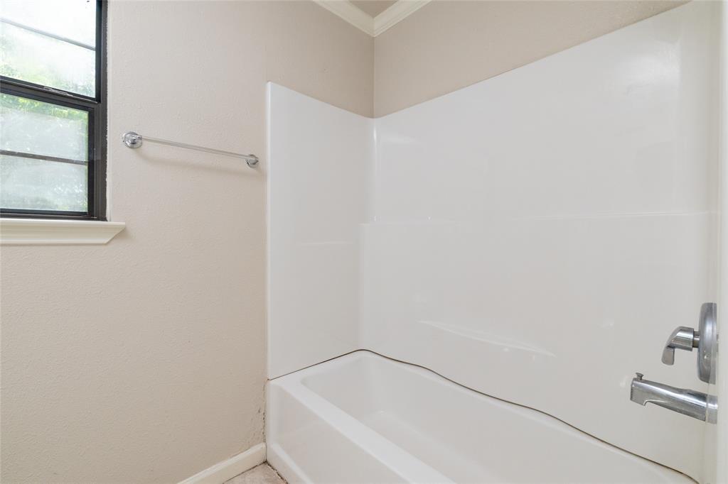 313 North Roe Street White Settlement, TX 76108 - Photo 23 of 33 Bathtub and shower combination featuring a white surround and chrome fixtures