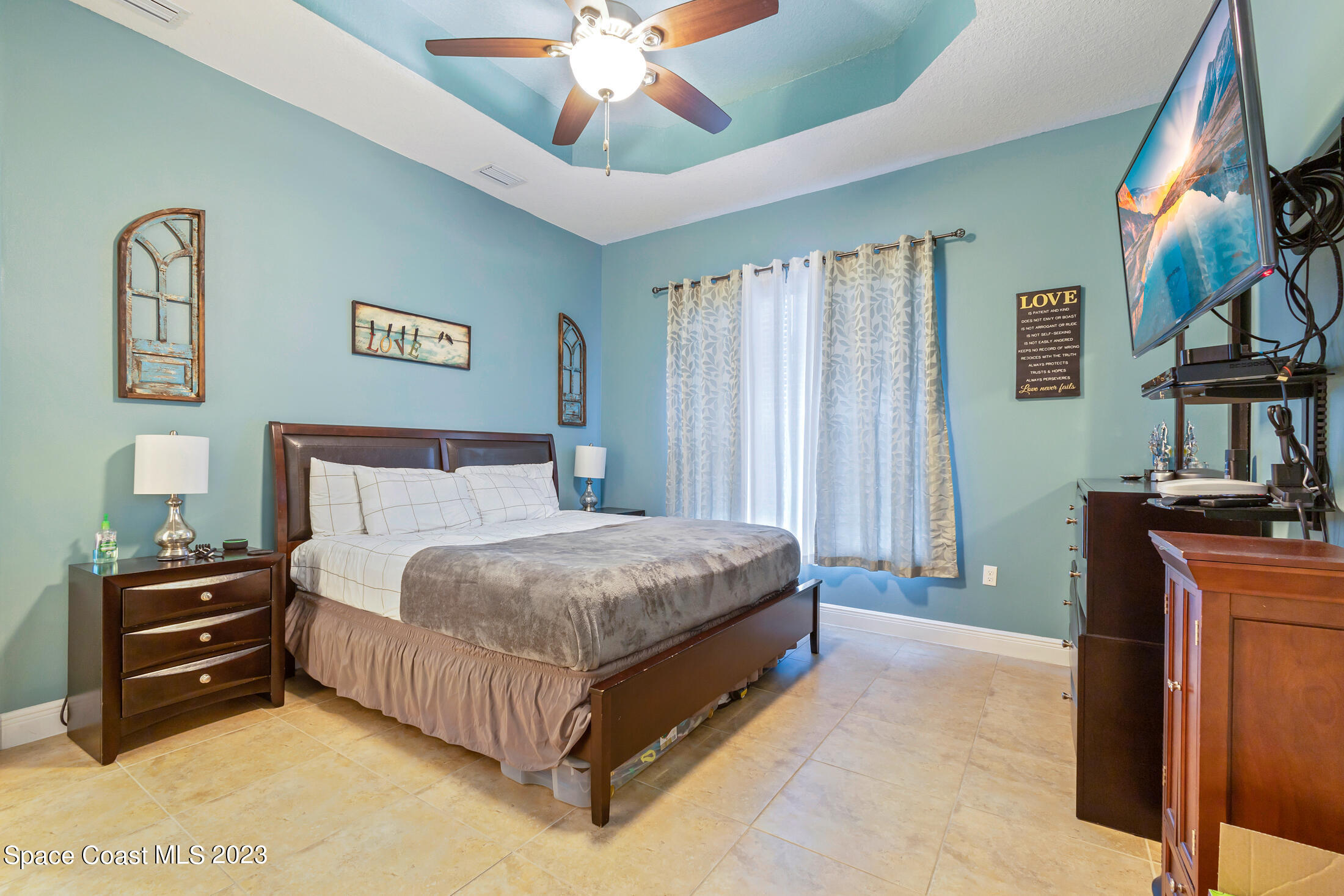 1840 Trimble Road Melbourne, FL 32934 - Photo 23 of 42 a spacious bedroom with a bed and a chandelier