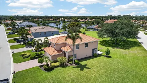 a view of multiple houses with a yard and entertaining space