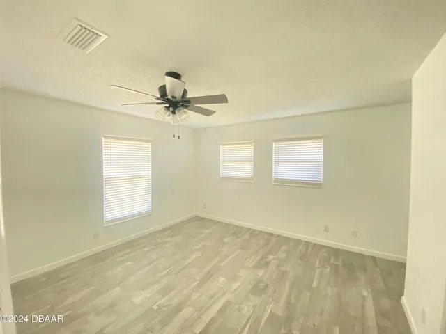 a view of a room with a window and a ceiling fan