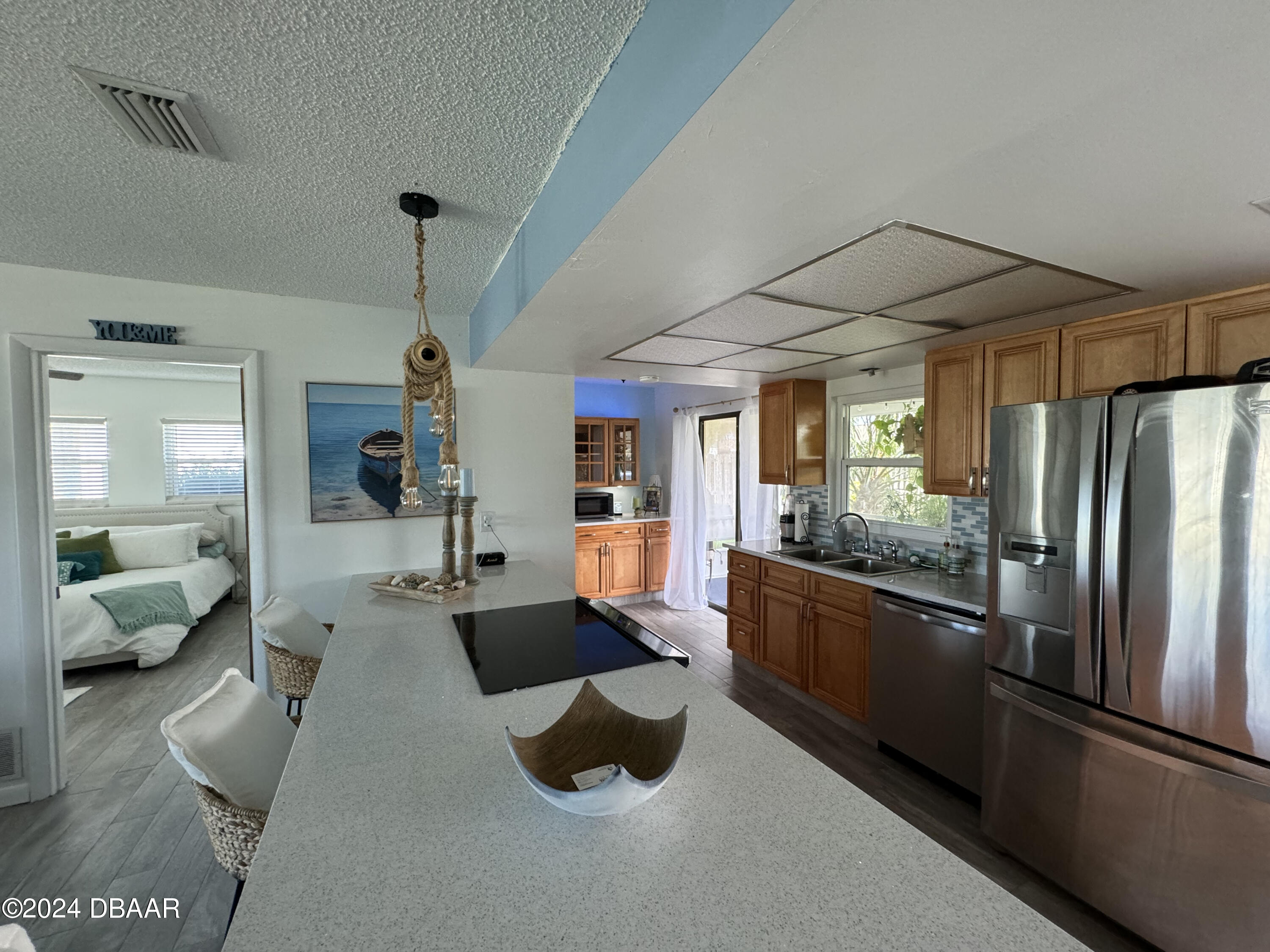 12 Ocean Crest Drive Ormond Beach, FL 32176 - Photo 26 of 31 a large open kitchen with stainless steel appliances kitchen island granite countertop a refrigerator a stove and a sink with couches