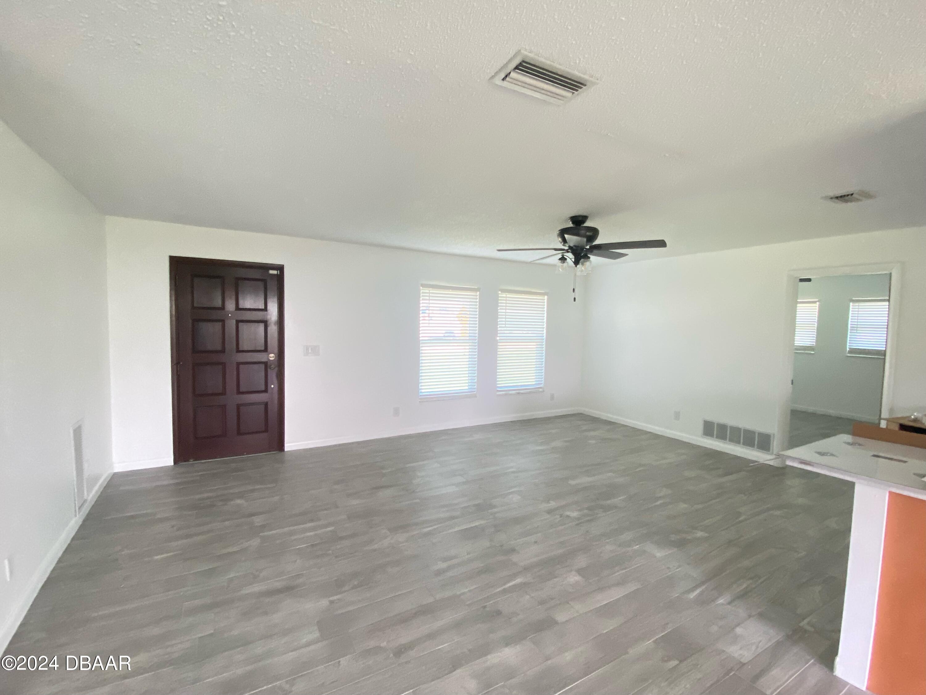 12 Ocean Crest Drive Ormond Beach, FL 32176 - Photo 4 of 31 an empty room with windows and ceiling fan