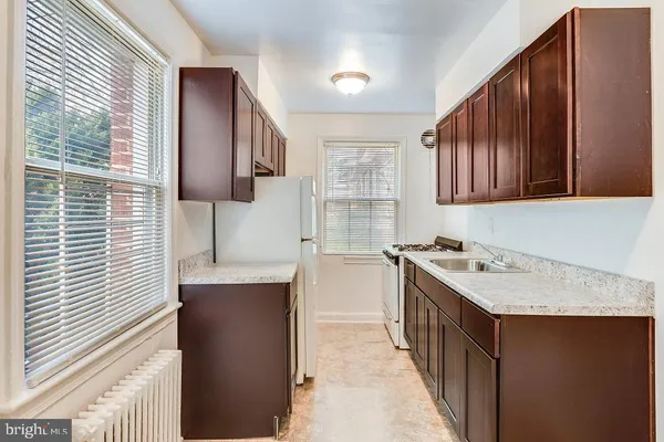 a kitchen with kitchen island granite countertop a sink stove and cabinets