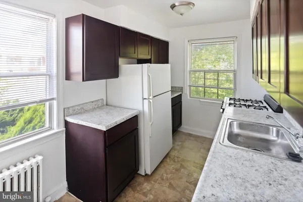 a kitchen with a stove a refrigerator and a sink