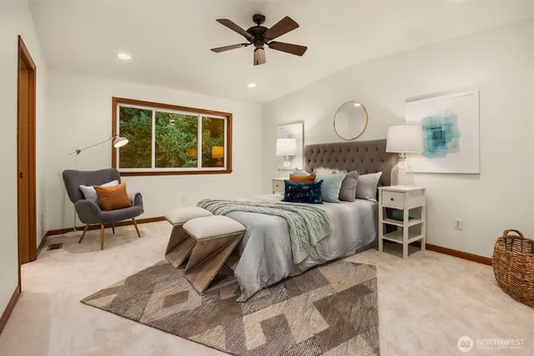 a spacious bedroom with a bed a chandelier and dresser