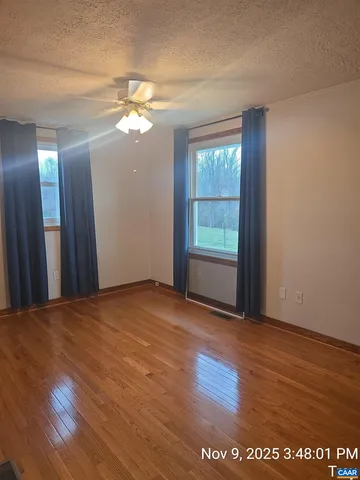 a view of a room with wooden floor and a window