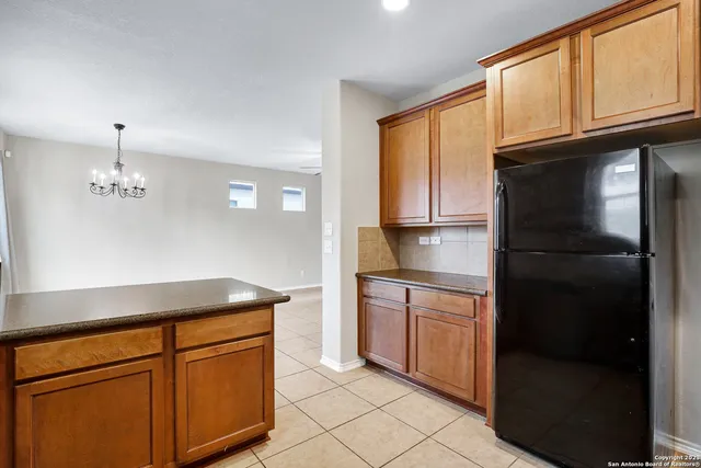 a kitchen with stainless steel appliances granite countertop a refrigerator a stove and a sink with cabinets
