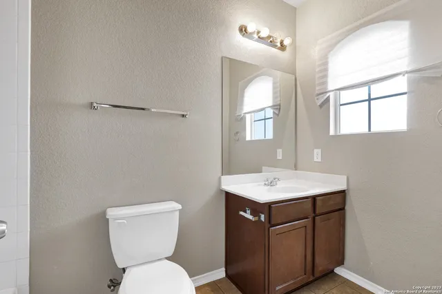 a bathroom with a toilet sink and mirror