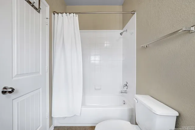 a bathroom with a shower curtain and a toilet