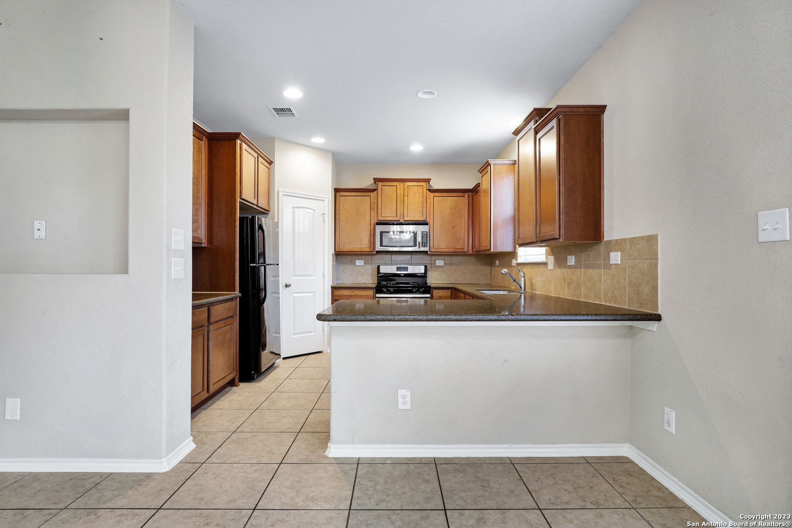 1331 Nicholas Manor San Antonio, TX 78258 - Photo 8 of 26 a kitchen with stainless steel appliances granite countertop a refrigerator and a sink