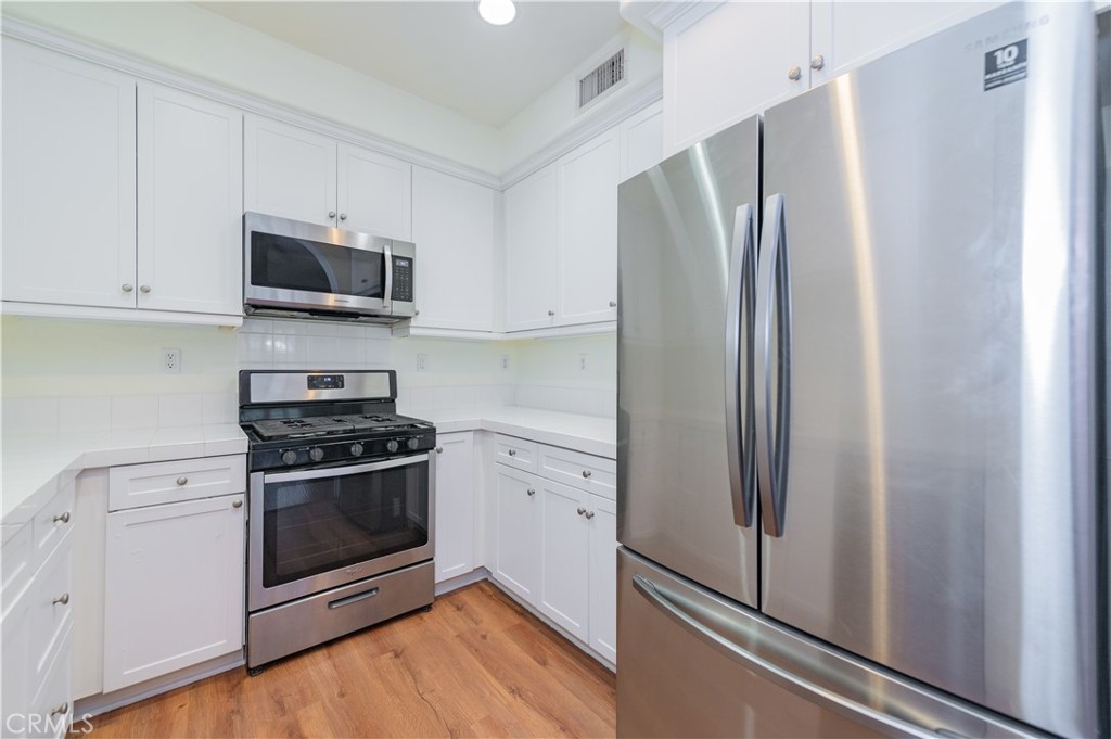 105 Hallmark Irvine, CA 92620 - Photo 8 of 32 a kitchen with stainless steel appliances a refrigerator stove and microwave