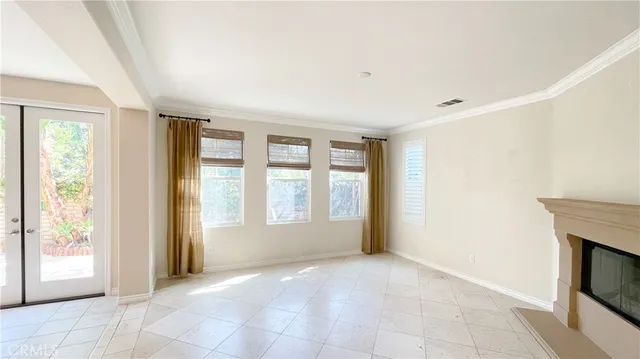 a view of an empty room with a fireplace and a window