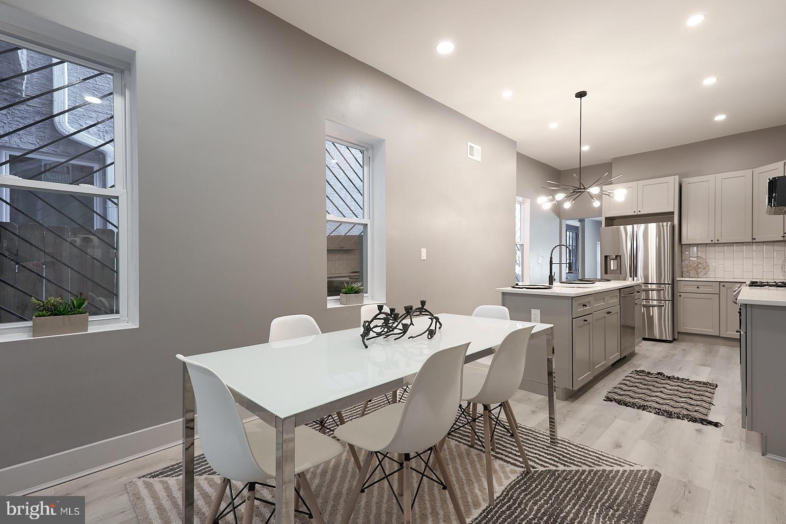 1630 North 26th Street Philadelphia, PA 19121 - Photo 13 of 50 a kitchen with a dining table chairs and white cabinets