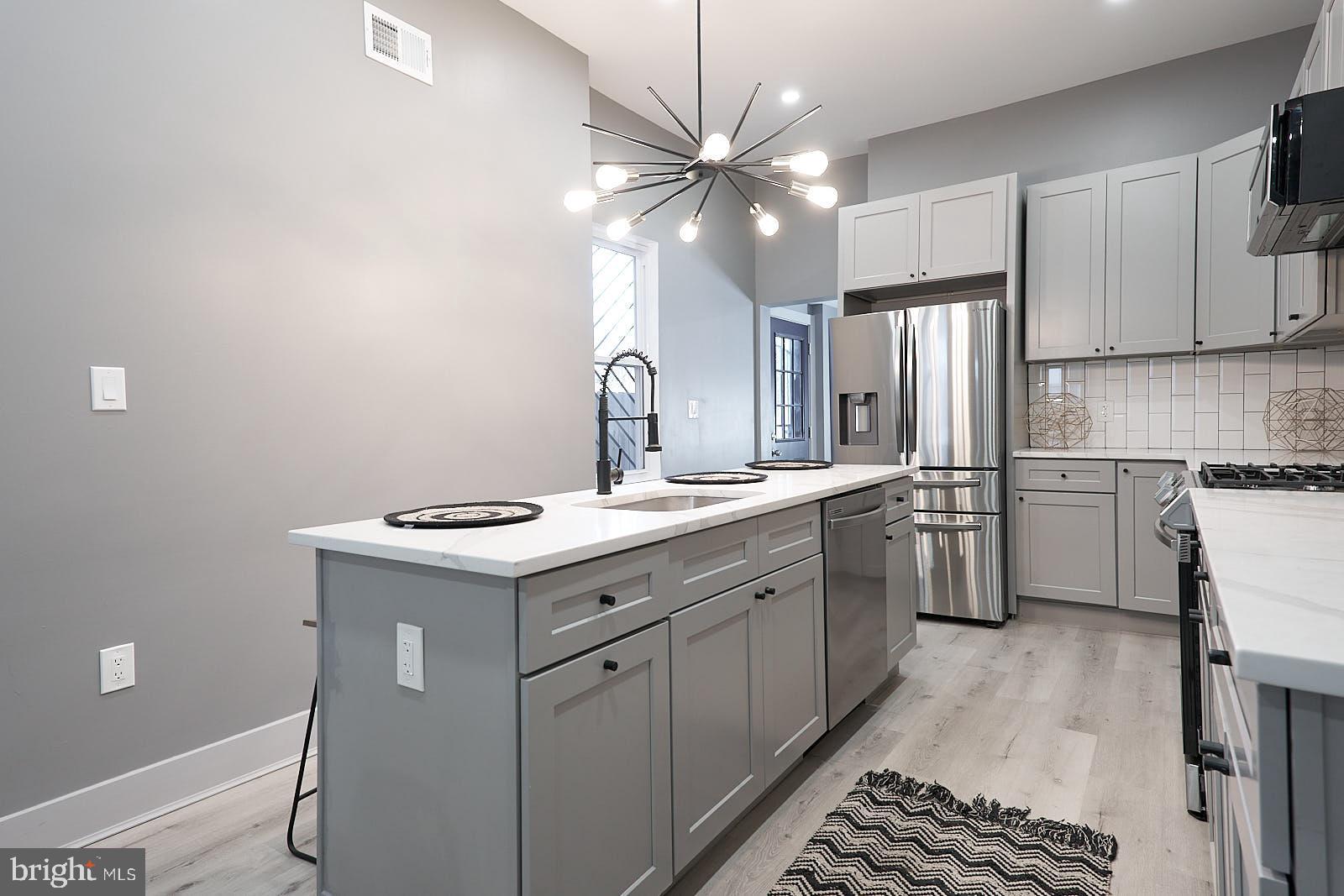 1630 North 26th Street Philadelphia, PA 19121 - Photo 20 of 50 a kitchen with a stove cabinets and a refrigerator