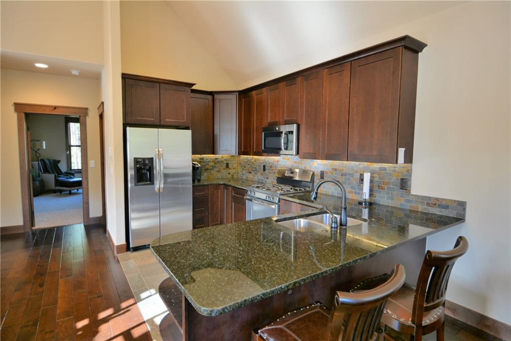 874 Independence Road, Unit 1C Keystone, CO 80435 - Photo 3 of 25 a kitchen with granite countertop a table chairs stove and refrigerator