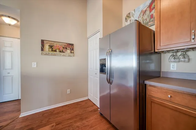 a view of a refrigerator in kitchen and an empty room