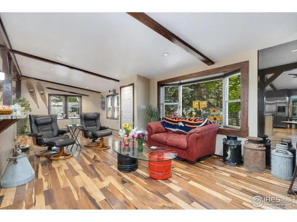 a living room with furniture large window and wooden floor