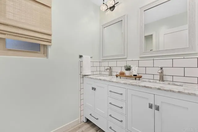 a kitchen with white cabinets and sink