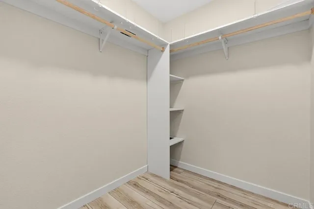 a view of walk in closet with empty racks