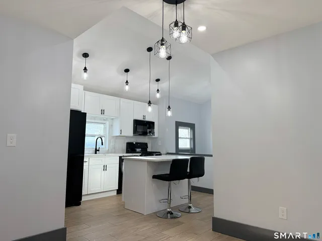 a open kitchen with kitchen island a sink stainless steel appliances and cabinets