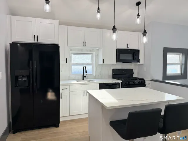 a kitchen with a sink a microwave a refrigerator and cabinets