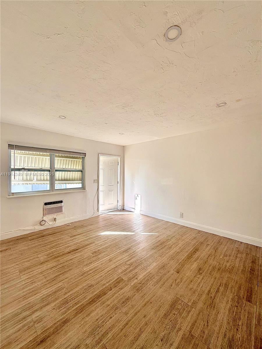 224 Southwest 10th Street, Unit 1 Hallandale Beach, FL 33009 - Photo 12 of 22 wooden floor in an empty room with a window