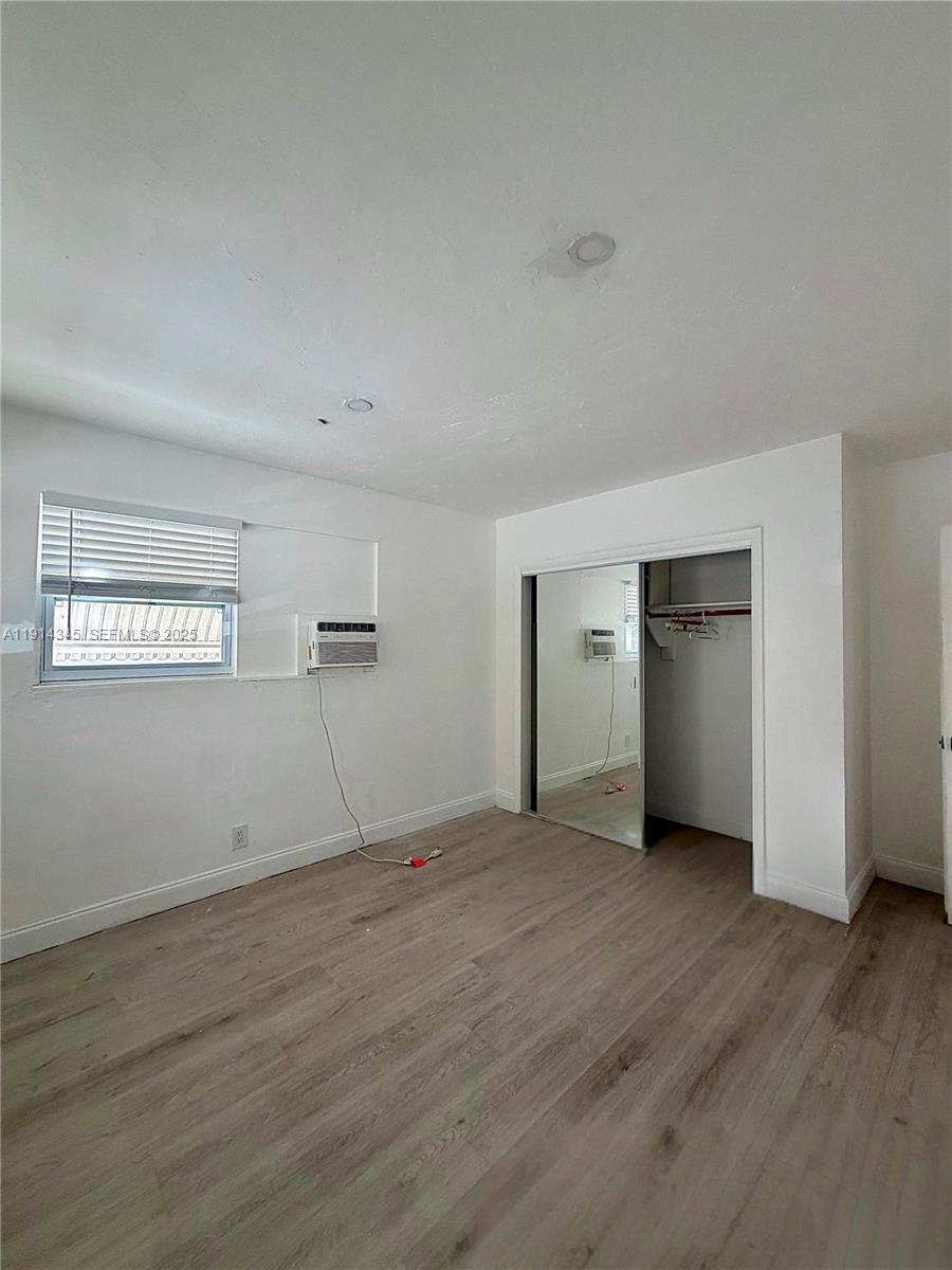 224 Southwest 10th Street, Unit 1 Hallandale Beach, FL 33009 - Photo 15 of 22 a view of an empty room with wooden floor and a window