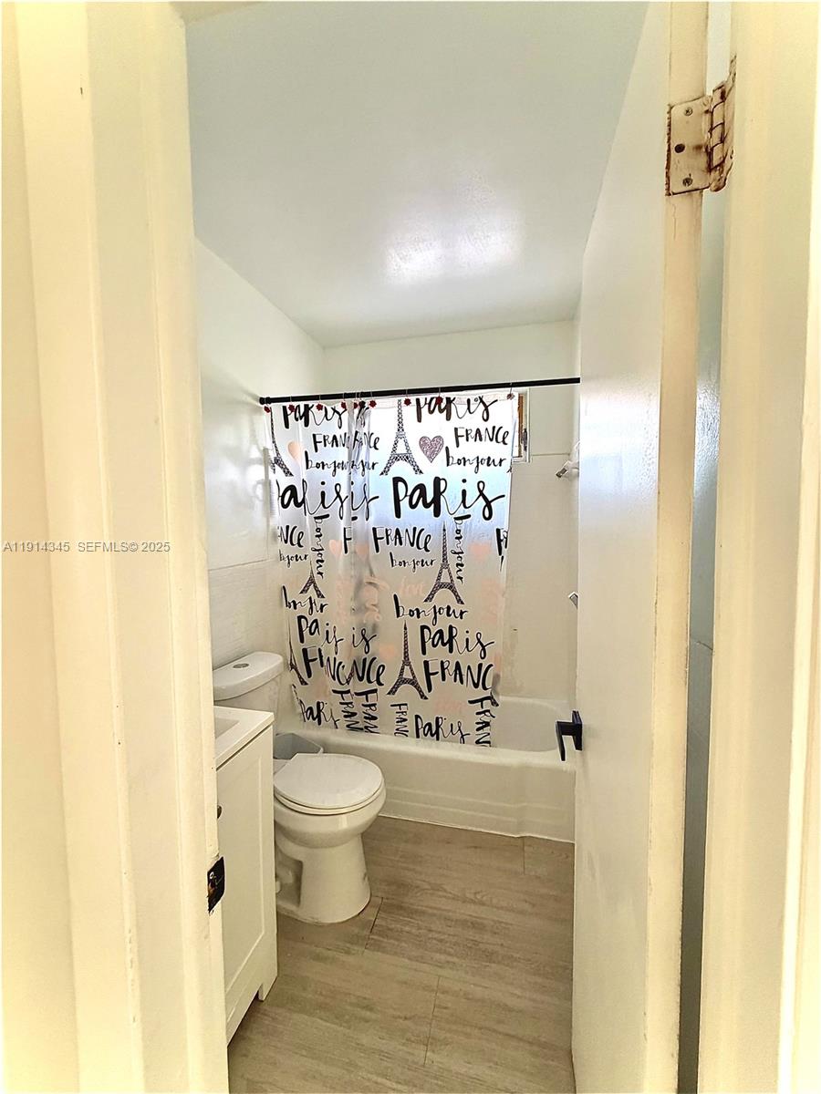 224 Southwest 10th Street, Unit 1 Hallandale Beach, FL 33009 - Photo 19 of 22 a bathroom with a toilet and a shower curtain