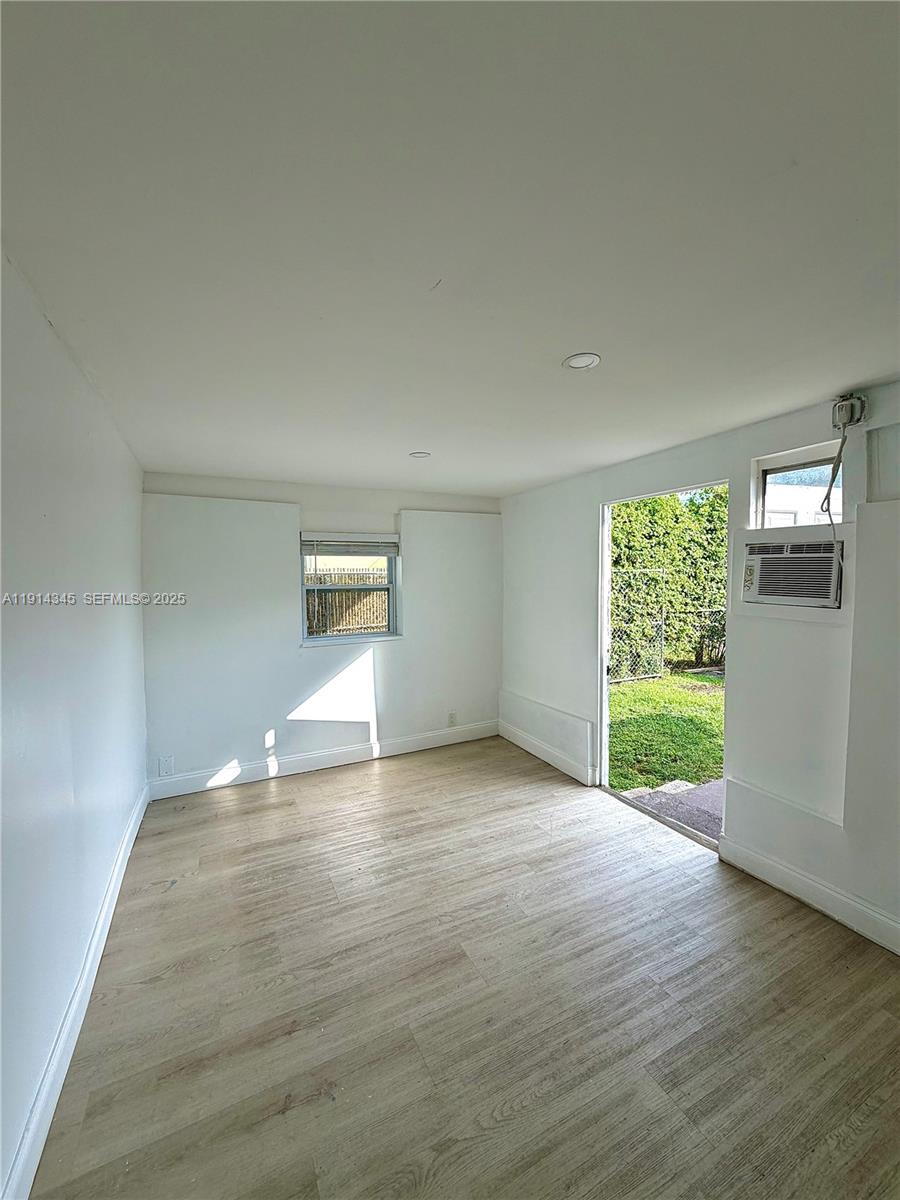 224 Southwest 10th Street, Unit 1 Hallandale Beach, FL 33009 - Photo 3 of 22 a view of empty room with wooden floor and fan