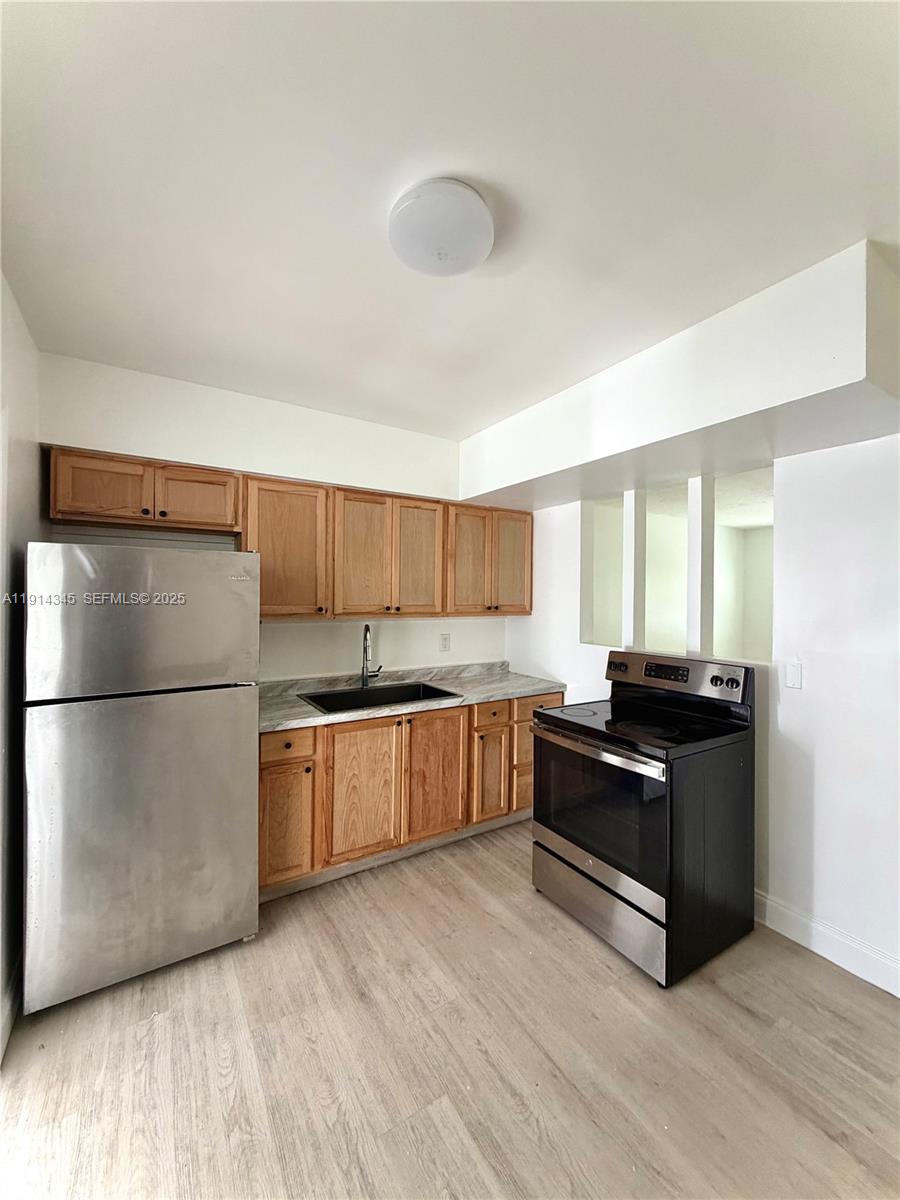 224 Southwest 10th Street, Unit 1 Hallandale Beach, FL 33009 - Photo 7 of 22 a kitchen with a refrigerator and a stove