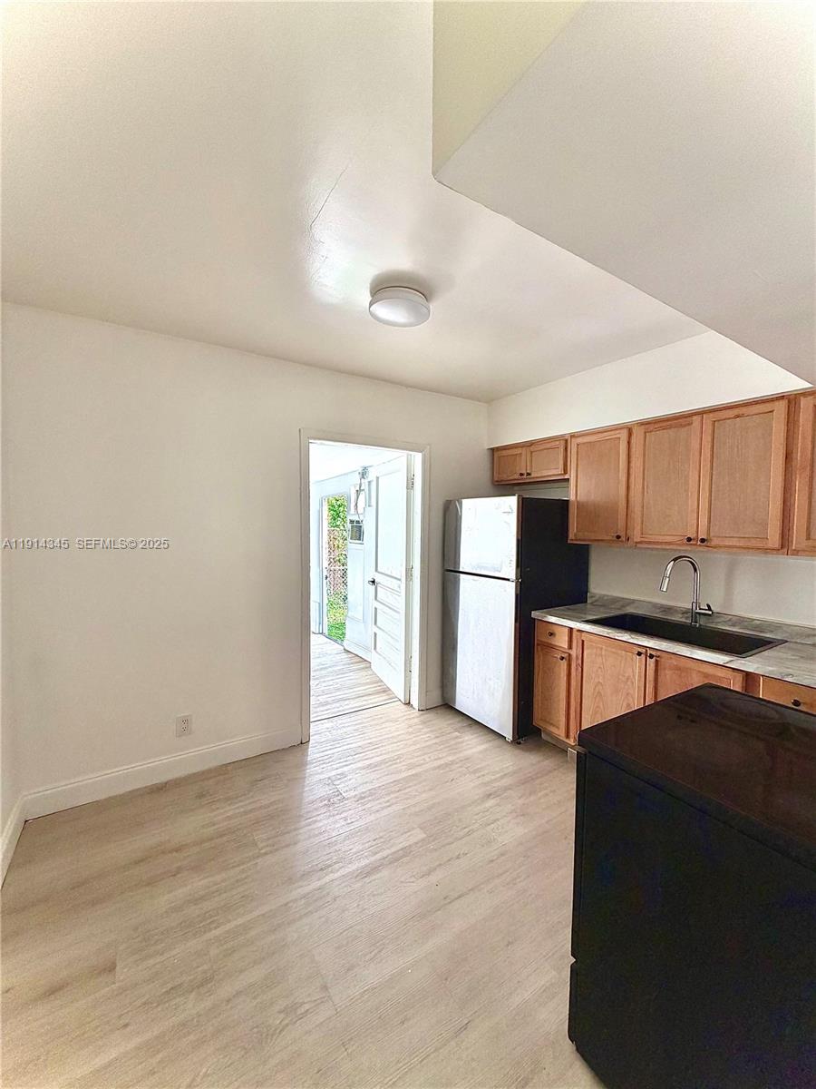 224 Southwest 10th Street, Unit 1 Hallandale Beach, FL 33009 - Photo 8 of 22 a view of a kitchen with wooden floor and electronic appliances