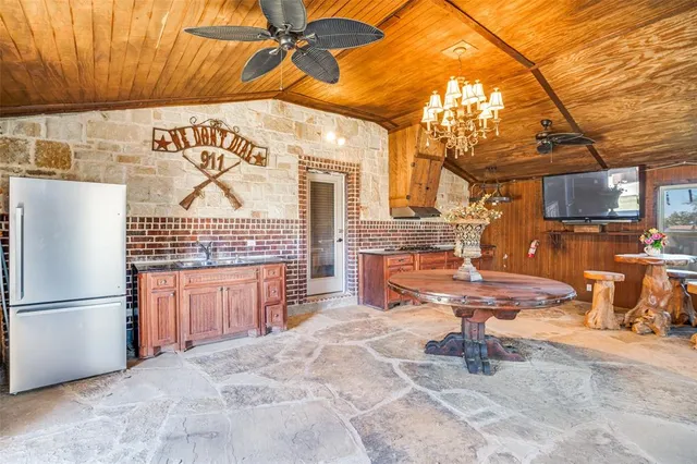 a kitchen with stainless steel appliances kitchen island granite countertop a refrigerator and a stove top oven