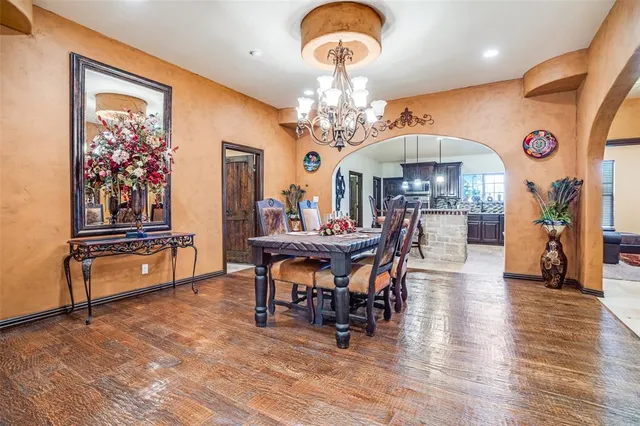 a view of a dining room with furniture a chandelier and wooden floor