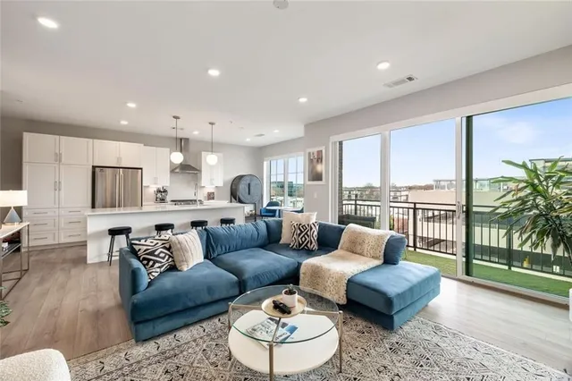 a living room with furniture kitchen and a wooden floor