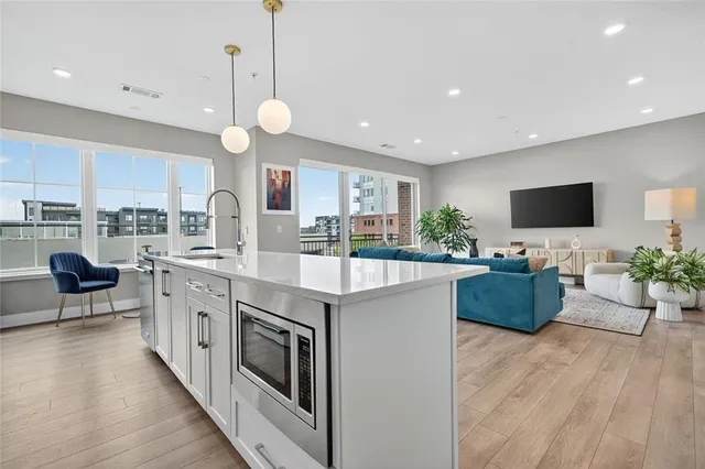 a kitchen with stainless steel appliances granite countertop a stove and a wooden floors