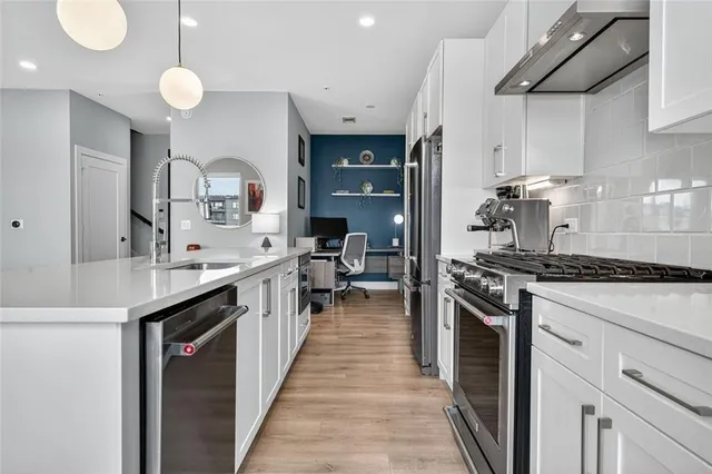 a kitchen with stainless steel appliances a sink stove and cabinets