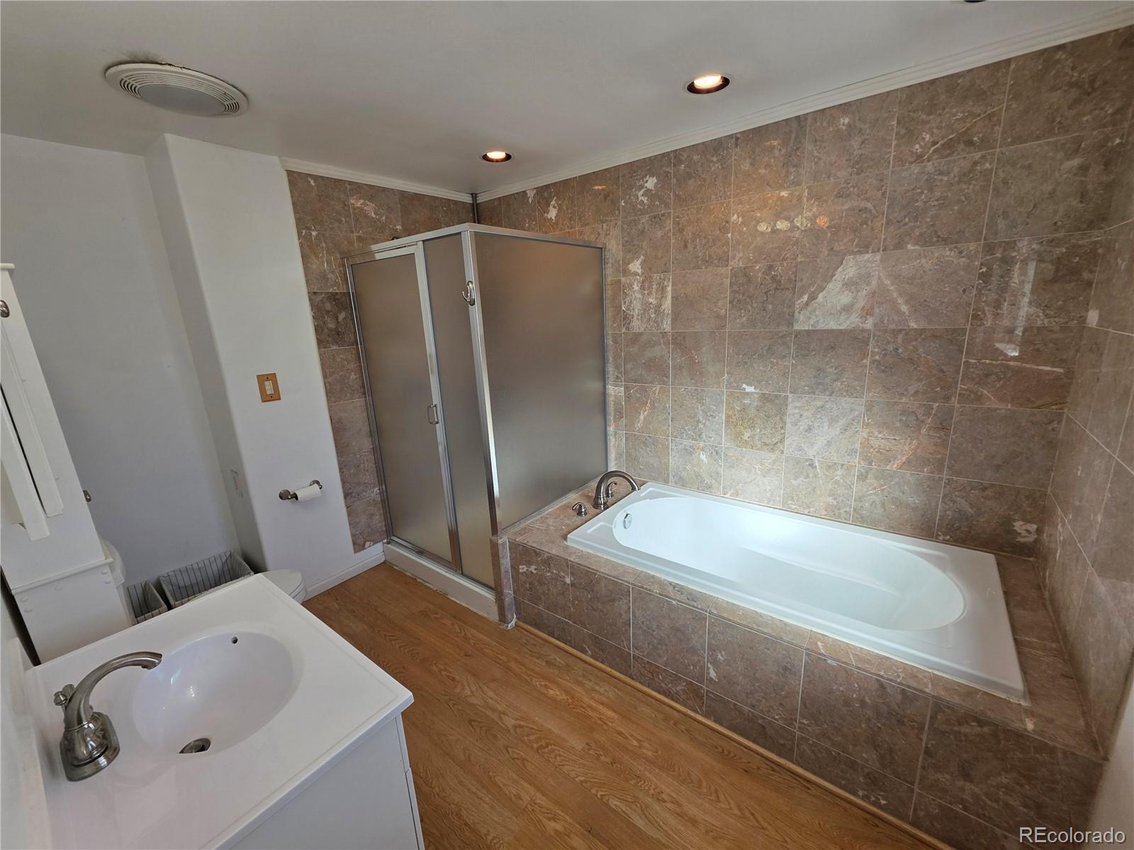 10439 Independence Street Broomfield, CO 80021 - Photo 15 of 30 a bathroom with a tub a sink and glass door shower