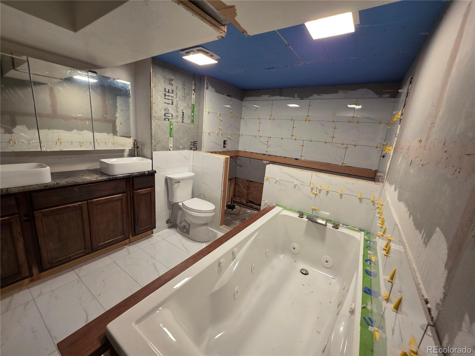 10439 Independence Street Broomfield, CO 80021 - Photo 24 of 30 a bathroom with a double vanity sink and mirror