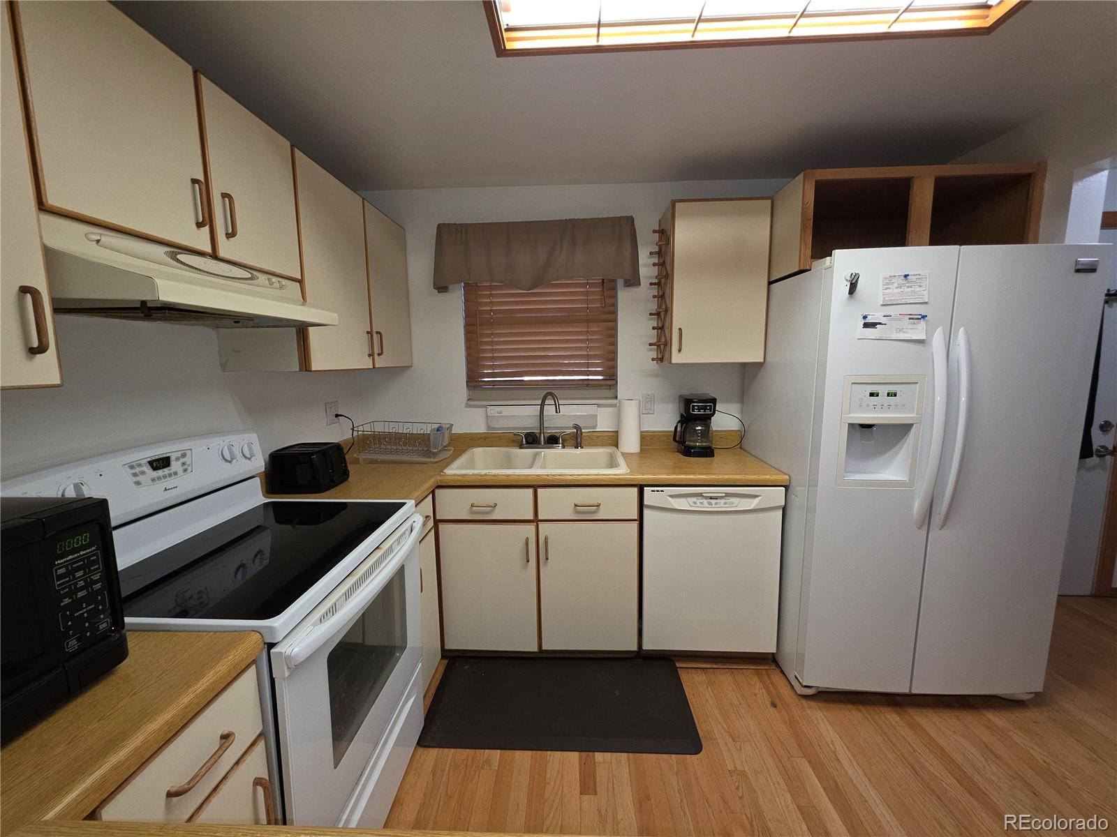 10439 Independence Street Broomfield, CO 80021 - Photo 5 of 30 a kitchen with a refrigerator a stove a sink and cabinets