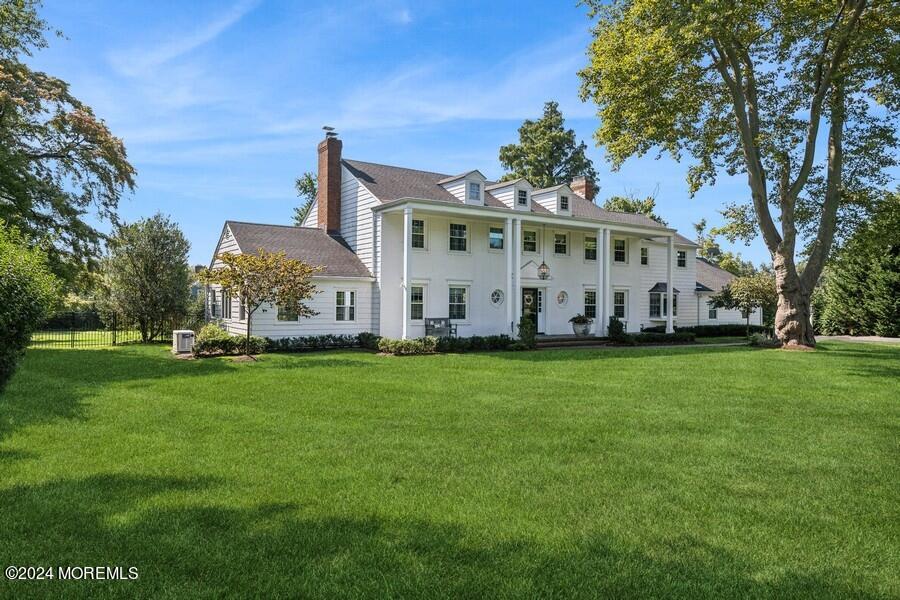 107 Rumson Road Rumson, NJ 07760 - Photo 3 of 46 a view of a white house that has a big yard with wooden fence