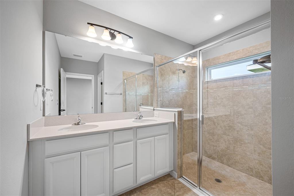 11230 High Noon Trail Parrish, FL 34219 - Photo 18 of 40 a bathroom with a shower sink and mirror