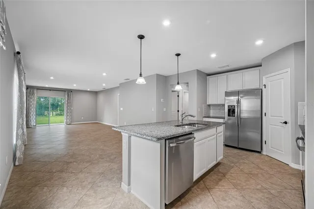 a kitchen with stainless steel appliances granite countertop a sink a stove and a refrigerator