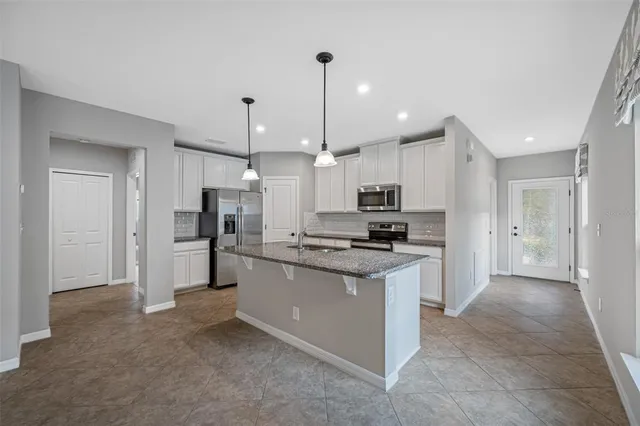 a kitchen with stainless steel appliances kitchen island a sink and a refrigerator