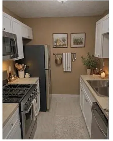 a kitchen with stainless steel appliances granite countertop a stove a refrigerator and a sink
