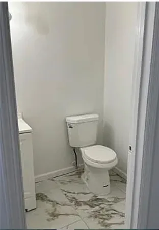 a white toilet sitting next to a shower