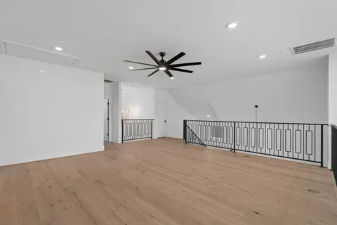 a view of wooden floor and a ceiling fan in a room