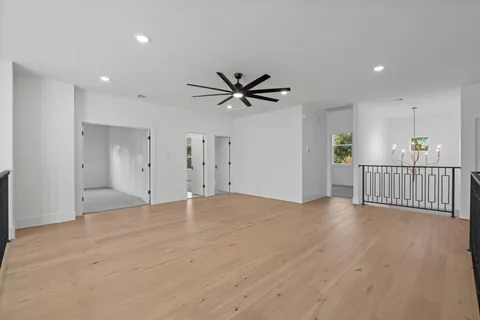 an empty room with fan and windows