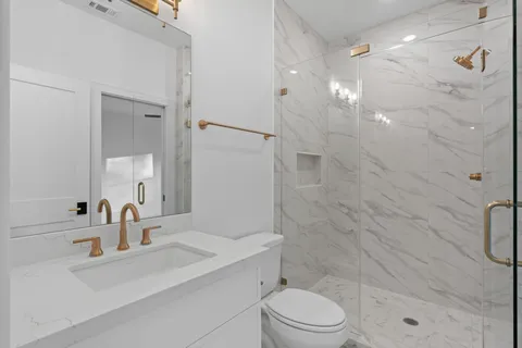 a bathroom with a sink a toilet and shower