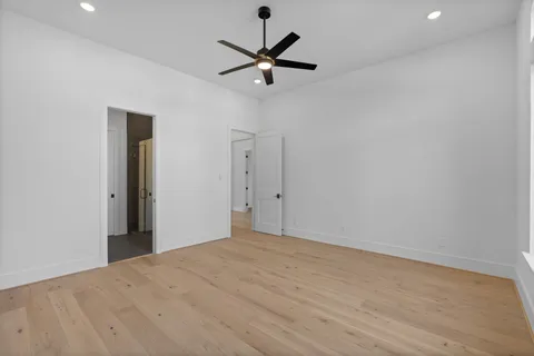 a view of a room with wooden floor and a ceiling fan