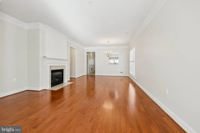 a view of empty room with wooden floor and fireplace